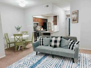 a living room with a couch and a kitchen at Warm 2-Bedroom Amongst Shaded Oaks in Corpus Christi