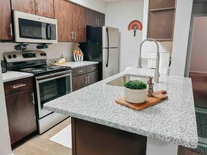 a kitchen with a counter with a sink and a stove at Warm 2-Bedroom Amongst Shaded Oaks in Corpus Christi