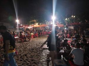 Eine Menschenmenge, die nachts am Strand sitzt in der Unterkunft MANIPON TRANSIENT HOUSE in San Juan
