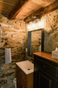 Baño de piedra con lavabo y espejo en The Goodville Suite en East Earl