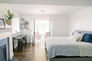 een slaapkamer met een bed, een bureau en een open haard bij The Goodville Suite in East Earl