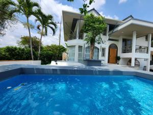 a house with a swimming pool in front of a house at SOVA Vcay Pool Villa 