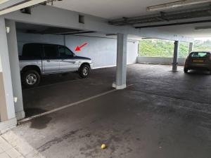 a car parked in a parking garage with a red arrow at PAPEETE - Kahaia Apartment in Papeete