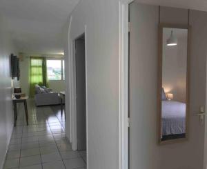 Sala de estar con cama y espejo en PAPEETE - Kahaia Apartment en Papeete