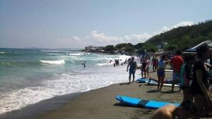 a group of people on a beach with surfboards at MANIPON TRANSIENT HOUSE in San Juan +10 photos