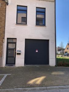 un edificio con dos puertas de garaje y dos ventanas en Enjoyvilla@sea, en Ostende