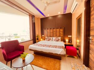 a bedroom with a large bed and a red chair at The Starlet Prime, A Hidden Peaceful Stay in Chandīgarh