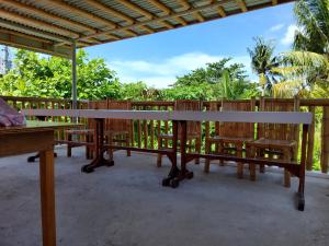 einen Tisch und Bänke auf einer Terrasse mit Bäumen in der Unterkunft Mandurah's Inn, Malapascua in Malapascua