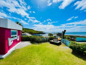 a pink house with a view of the ocean at 灣境海邊小屋 in Eluan