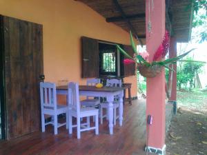 Puerto Viejo的住宿－Vanilla Jungle Lodge - Rainforest Waterfall Garden，一间带桌子和白色椅子的用餐室