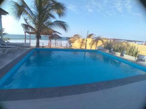 une grande piscine bleue à côté de la plage dans l'établissement Casa de Playa Las Fragatas de Punta Mero, à Canoas de Punta Sal