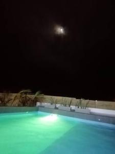 una piscina por la noche con la luna en el cielo en Casa de Playa Las Fragatas de Punta Mero, en Canoas de Punta Sal