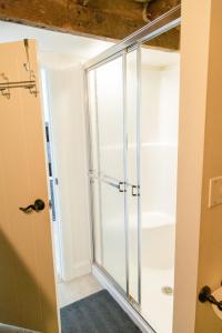 Una puerta de ducha de cristal en una habitación con baño. en The Goodville Suite en East Earl