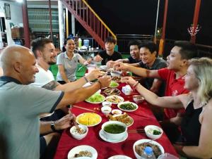 a group of people sitting around a table eating food at Ba Bể Homestay - Nhà Nghỉ Trần Thực in Bak Kan