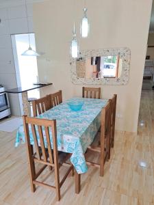 a dining room table and chairs with a blue bowl on it at Casa de Praia do Adriano in Itapoa
