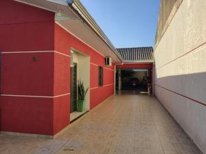 伊瓜蘇的住宿－Quarto aconchegante na terra das cataratas，一座有红色墙壁的建筑的空走廊