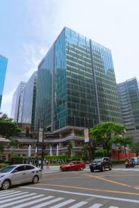 a large glass building with cars on a city street at Uptown Parksuites 1BR with Wi-Fi, Free Netflix, Washer & Pool View in Manila