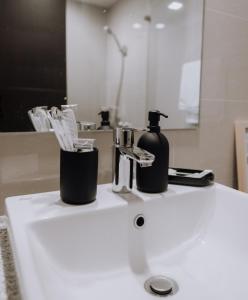 a bathroom sink with a bottle of soap on it at Uptown Parksuites 1BR with Wi-Fi, Free Netflix, Washer & Pool View in Manila