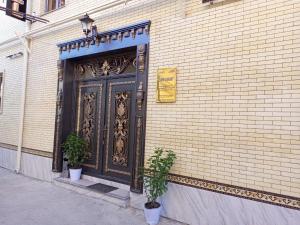 a black door on the side of a brick building at Dari Zanjir in Samarkand