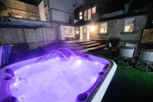 a purple bath tub in a yard with a church at Foxlow Grange By Muse Escapes in Buxton