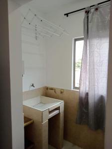 a bathroom with a sink and a shower curtain at zara's apartamento en coveñas in Coveñas