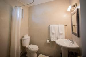 a bathroom with a white toilet and a sink at Ocean Villa Guam in Tamuning
