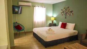タムニンにあるOcean Villa Guamのベッドと椅子付きのホテルルーム