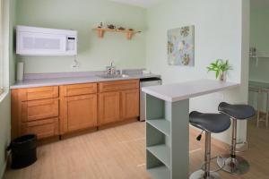 a kitchen with a sink and a counter with two stools at Ocean Villa Guam in Tamuning