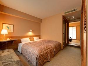 a hotel room with a large bed and a window at the Kinta Naeba in Yuzawa