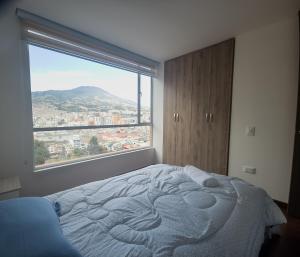 1 dormitorio con cama y ventana grande en Apartamento panorámico de lujo en el Centro de Pasto, en Pasto