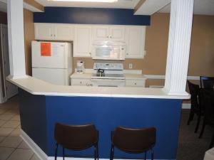 - une cuisine bleue et blanche avec des appareils et des chaises blancs dans l'établissement Lake View Golf Resort Villa 1301, à Calabash