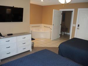 a bedroom with a bed and a bathroom with a tub at Brunswick Plantation Studio Home 1301L in Calabash