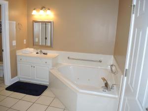 a white bathroom with a tub and a sink at Brunswick Plantation Studio Home 1301L in Calabash
