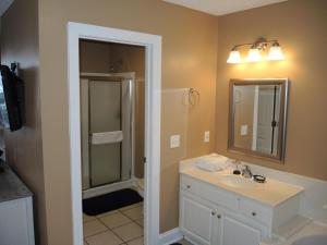 a bathroom with a sink and a shower with a mirror at Brunswick Plantation Studio Home 1301L in Calabash