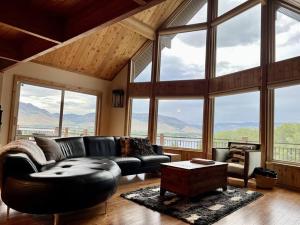 a living room with a leather couch and large windows at Snowbasin + Powder Mountain + Spa + Eden in Eden