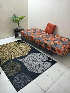 un sofá sentado en una habitación con dos alfombras en Homestay Itqan Seri Iskandar en Seri Iskandar
