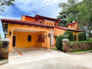 a large yellow house with a driveway at Estella Pool Villas Pattaya Formerly Chivani Pattaya in Na Jomtien