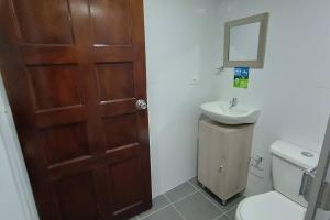 uma casa de banho com um WC, um lavatório e uma porta em Apartamento Nuevo y Central em Santa Rosa de Viterbo
