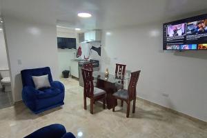 Apartamento Nuevo y Central في Santa Rosa de Viterbo: غرفة معيشة مع طاولة وكراسي وتلفزيون