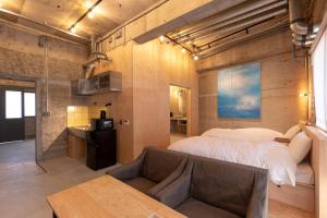 ein Schlafzimmer mit einem großen Bett und einem Sofa in der Unterkunft HAJIMARI Beppu in Beppu