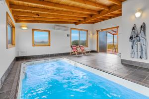 a swimming pool in a house with a wooden ceiling at Peace & Plenty in Swansea