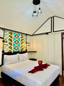 a white bed with a red ribbon on it at Lanta L.D. Beach Bungalow in Ko Lanta +128 photos