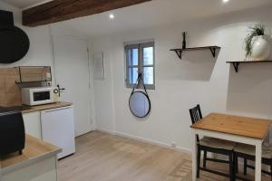 a kitchen with a table and a mirror on the wall at Charming studio in the historic centre in Montpellier
