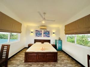 een slaapkamer met een bed en twee ramen bij Little Paradise in Weligama
