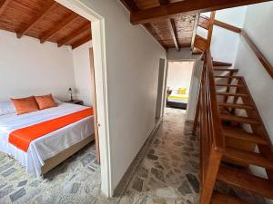 ein Schlafzimmer mit einem Bett mit orangefarbener Bettwäsche und einer Treppe in der Unterkunft Excelente ubicación Unicentro in Medellín