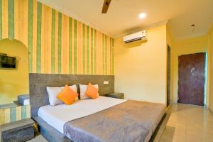 a bedroom with a bed with orange pillows at Swastic Hotel at Calangute GOA in Calangute