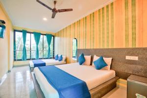 a bedroom with two beds and a ceiling fan at Swastic Hotel at Calangute GOA in Calangute