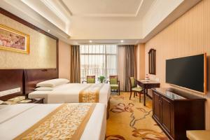 a hotel room with two beds and a flat screen tv at Vienna Hotel Shenzhen International Airport in Bao'an