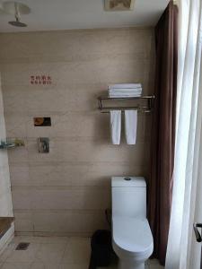 a bathroom with a toilet and a towel rack at Harbin Huaxi Hotel - Ice World Branch in Harbin