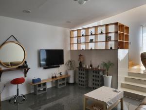 a living room with a tv and a mirror at House MOZAC in Jeju